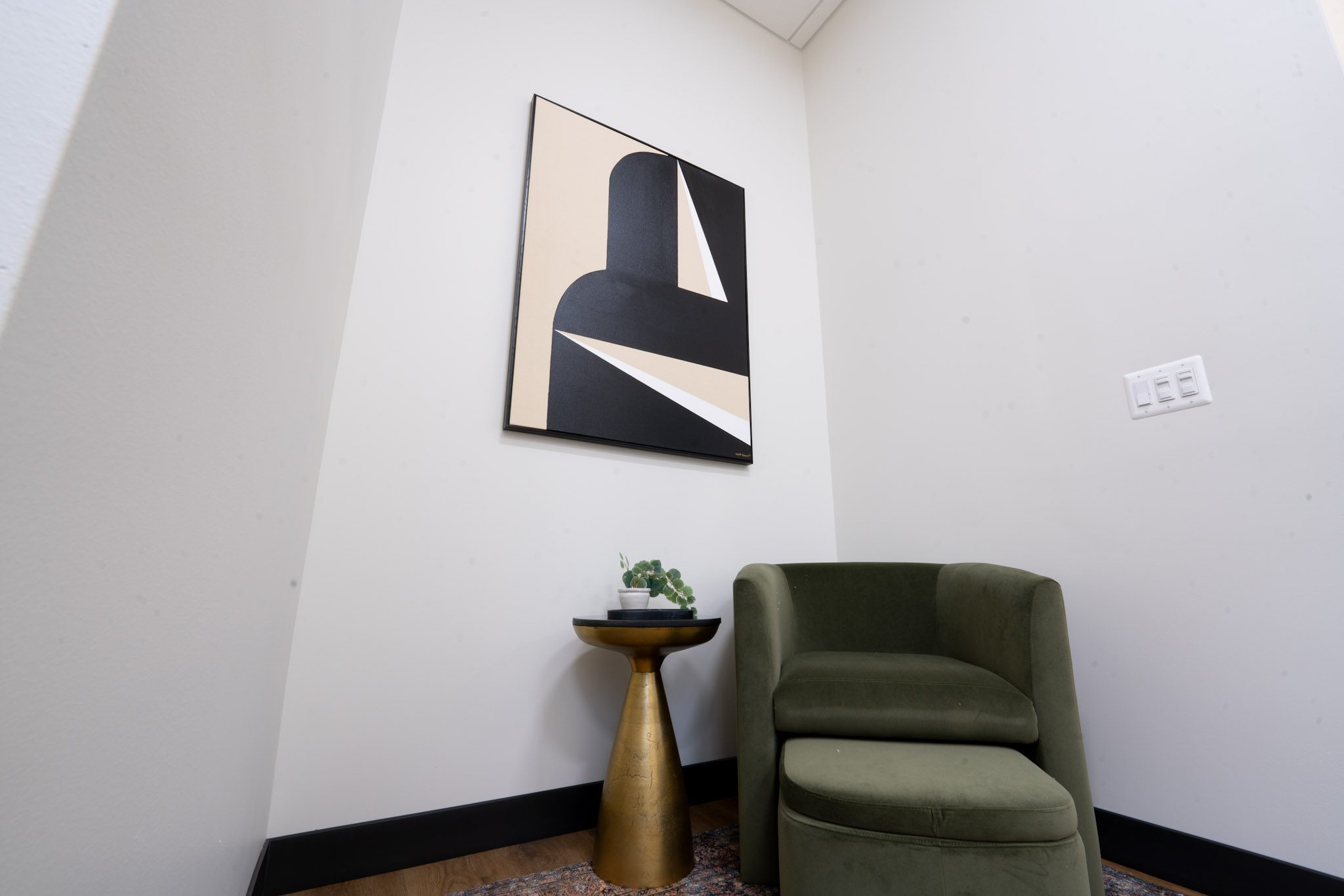 Aesthetic Artistry Laser Center waiting room with a green chair and gold side table